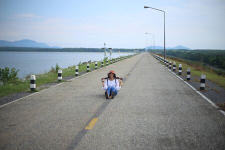 Woman sitting on the streets of the reservoirの写真素材