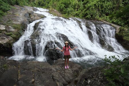 Woman standing on the rocks at Khao Soi Dao waterfall in Chanthaburi, Thailandの写真素材
