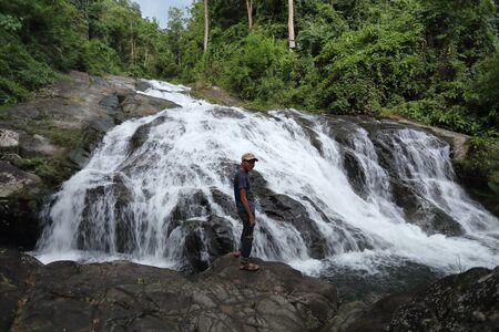 Man standing on the rocks at Khao Soi Dao waterfall in Chanthaburi, Thailandの写真素材