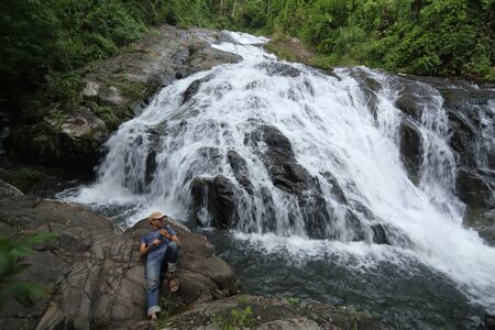 man lying on the rocks at Khao Soi Dao waterfall in Chanthaburi, Thailandの写真素材