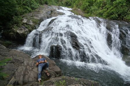 man lying on the rocks at Khao Soi Dao waterfall in Chanthaburi, Thailandの写真素材