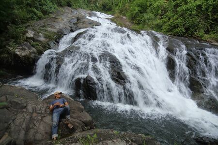 man lying on the rocks at Khao Soi Dao waterfall in Chanthaburi, Thailandの写真素材