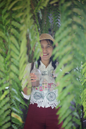 Unidentified Thai girl with a cup of coffee in the park in Pattaya, Thailand.の写真素材