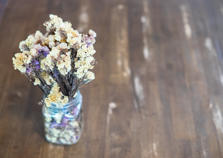 Dried flowers in a vase are located on a wooden table.selective focus and copy space.の写真素材