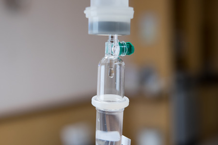 Close up saline drip for patient in hospital room. Patient on the bed.の写真素材