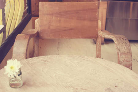flower in vase on the wood texture background in coffee shop with a retro vintage filter effectの写真素材