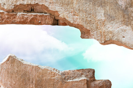 blue sky hole in aged brick wall background
