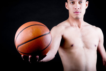 Asian young basketball player on black background