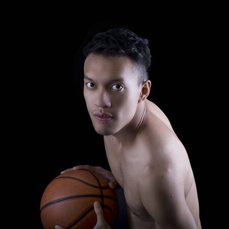 Asian young basketball player on black backgroundの写真素材