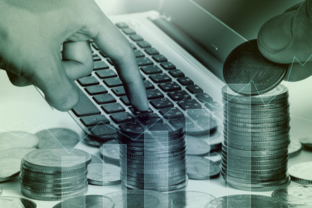 Double exposure of labtop of coins for finance and banking concept