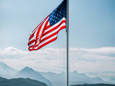 American flag waving in the wind against the background of the mountains.の素材