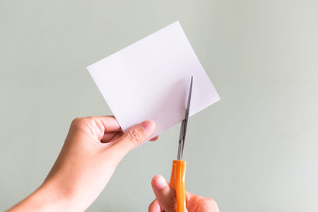Cutting white paper with scissors