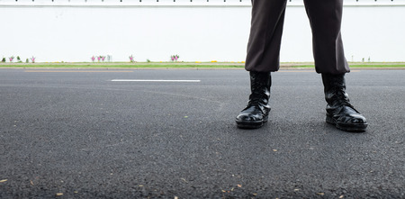 Close up of black combat boots of police man on the streetの写真素材