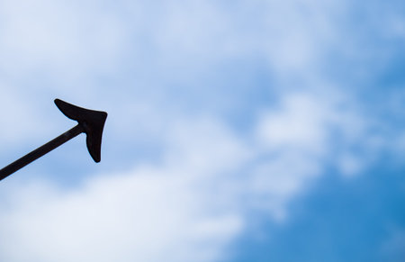 Blue sky with clouds background and black arrow