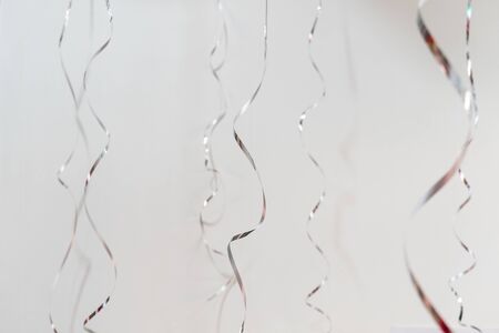 Silver silk curly ribbons on white backgroundの写真素材