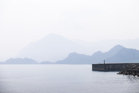 View of foggy ocan landscape with mountain and sky