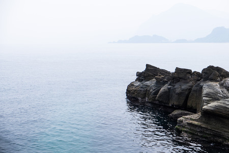 Landscape of foggy ocean with huge rocksの写真素材