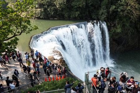 Shifen, Taiwan - April 1, 2017 : Tourists visit beautiful Shifen waterfall scenic area with rainbow