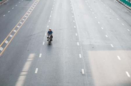 Bangkok, Thailand - April 16 : Alone man riding motorbike on the road