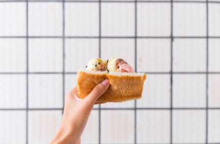 Bread ice cream on hand with grid white backgroundの写真素材