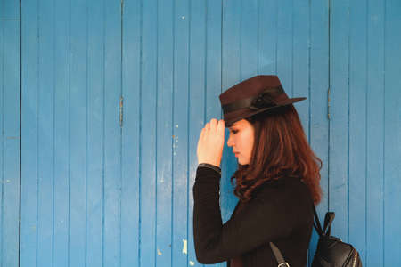 Pretty woman thinking with blue door backgroundの写真素材