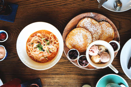 Top of pancakes with topping and spaghetti with wood tableの写真素材