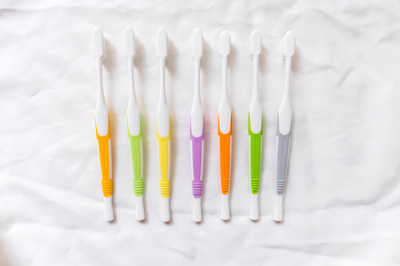 Old colorful toothbrushes on white background, top viewの写真素材