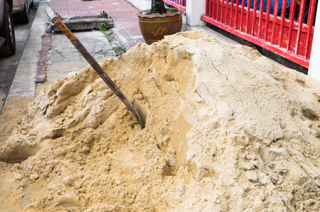 Shovel on a pile of sand for construction work at the streetの写真素材