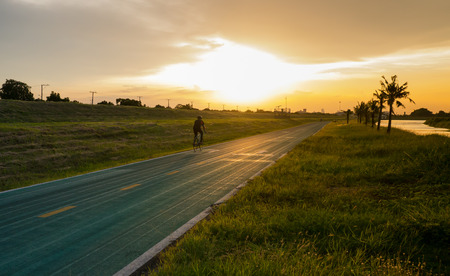 Man spin bicycle moving in the sunsetの写真素材
