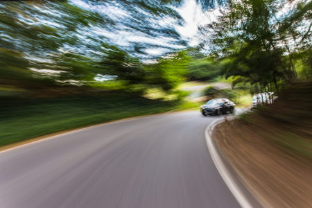 Blurred motion car moving fast on road.