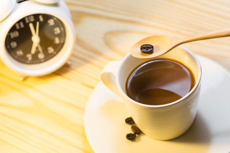 Closeup coffee cup with alarm clock in morning light . ( select ive focus and use soft image )の写真素材