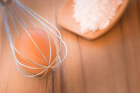 Still life egg in whisk and flour on Ladle wood selective focus and use soft light.の写真素材