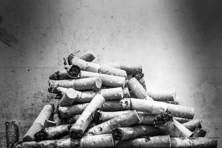 Cigarette butts with on grunge wall texture.の写真素材