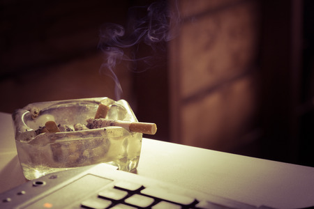 Still life cigarette and glass ashtray. Some man like smoking in work time for make idea.の写真素材