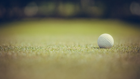golf ball on the green and selective focus on 16:9 picture side. vintage tone.の写真素材
