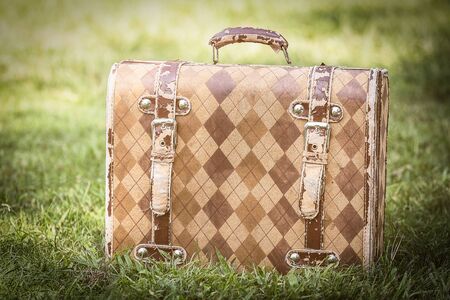 Old briefcase on grass  in vintage color.の写真素材