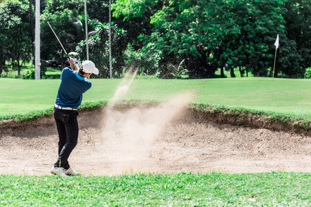 Stop action yong asian golfer after explosion sand bunker.の写真素材