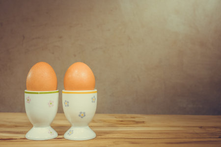Eggcup and boiled egg, on wooden table.の写真素材