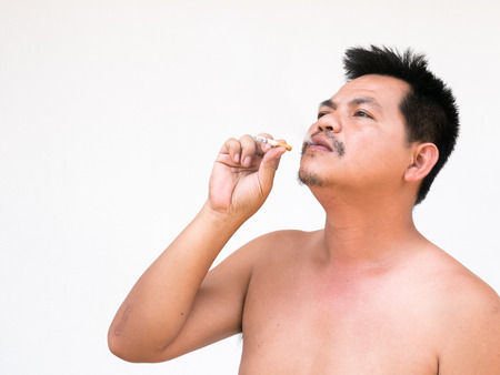 Adult asian man lighting up a cigarette. his face look old  shabby andGrey Hair by  toxic from cigarette.の写真素材