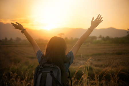 Girl backpack adventure look at mountain inthe sunset time.の写真素材