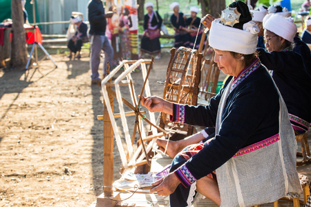 CHIANGRAI -THAILAND DECEMBER 7: Unidentified Tai Lue show weaving and spin cotton thread in amazing 10 triber of maesai Festival at on December 7, 2015 in Chiangrai,Thailandのeditorial素材