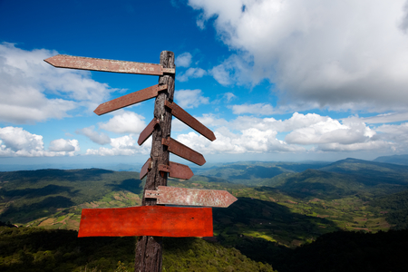 Empty plank and wood guide post on the blue sky with Mountain background.の写真素材