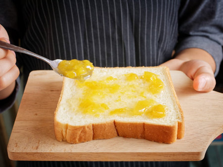 Red strawberry and peach yellow jam on plank wood and slice bread.