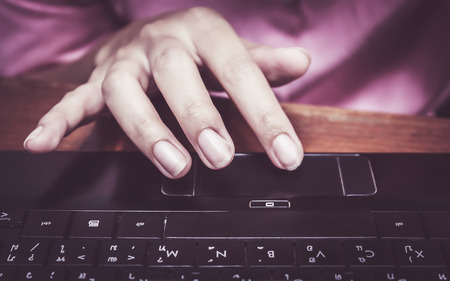 Woman hand presses on touch pad mouse laptopの写真素材