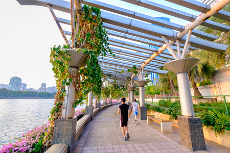 Bangkok, Thailand - April 25, 2016: Men are running in Benjakitti park, Bangkok downtown city at dusk on April 25, 2016.のeditorial素材