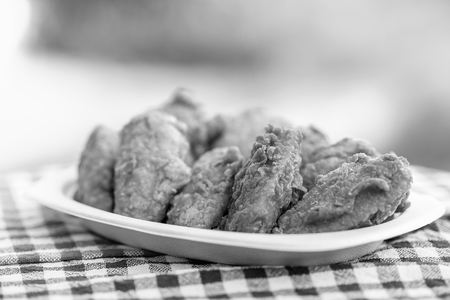 A plate of fresh, hot, crispy fried chicken on plaid towelの写真素材