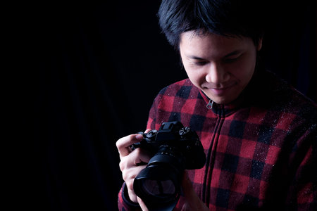 Photographer in action on a black background. Low key