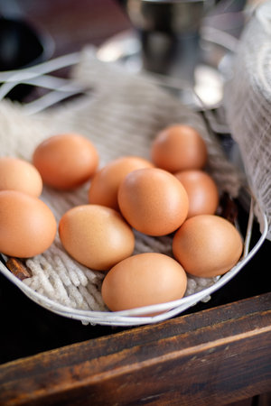 Chicken eggs in basket on wooden table