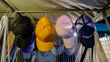 Nakhon Ratchasima, Thailand - March 15, 2019: Hat shop in Sikhio night market a famous night market where many people come to try Thai food and go shopping in Korat, Thailandのeditorial素材