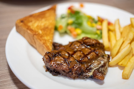 Black pepper pork steak served with bread and potato chips